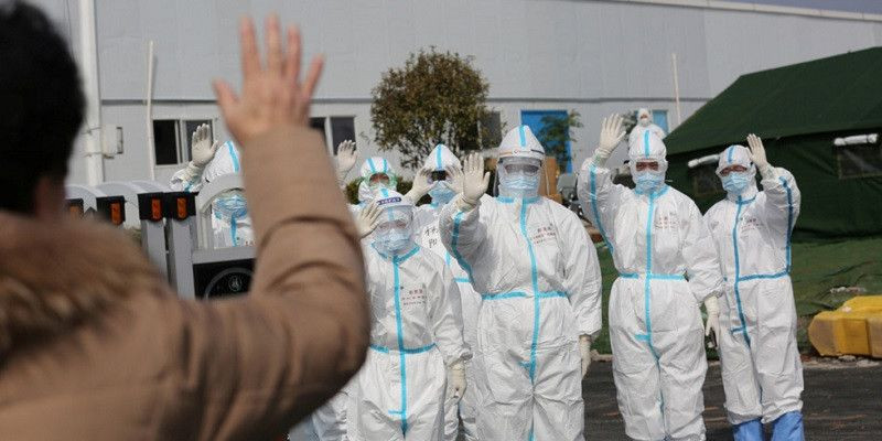 Tim medis melambaikan tangan pada pasien virus corona yang baru sembuh di Wuhan, China/Reuters