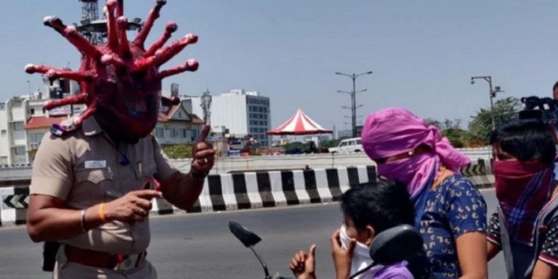 Polisi di Chennai mengenakan helm corona saat menyemprit warga yang masih keluar rumah di tengah pandemi virus corona/India Today