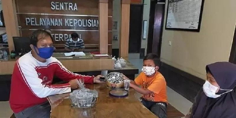 Mochamad Hafidh saat didampingi ibunya sumbangkan tabungan ke polsek/Net