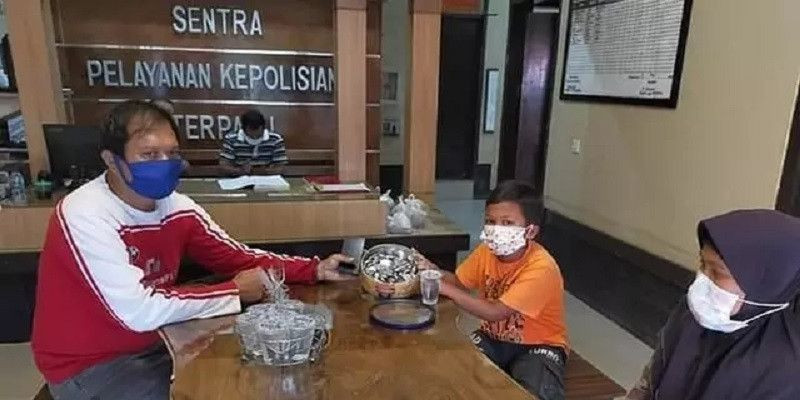 Mochamad Hafidh saat didampingi ibunya sumbangkan tabungan ke polsek/Net