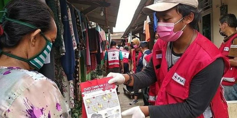 Relawan PMI membagikan paket PHBS ke warga yang tinggal di Kelurahan Pegadungan, Jakarta Barat