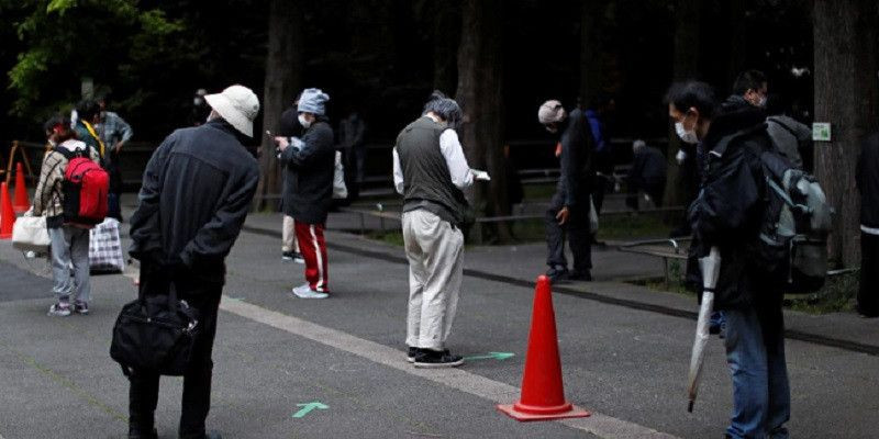 Warga Jepang mempraktikkan jarak sosial ketika mengantri pemberian bantuan makanan, di bawah keadaan darurat nasional Covid-19 di ibukota Tokyo/Reuters
