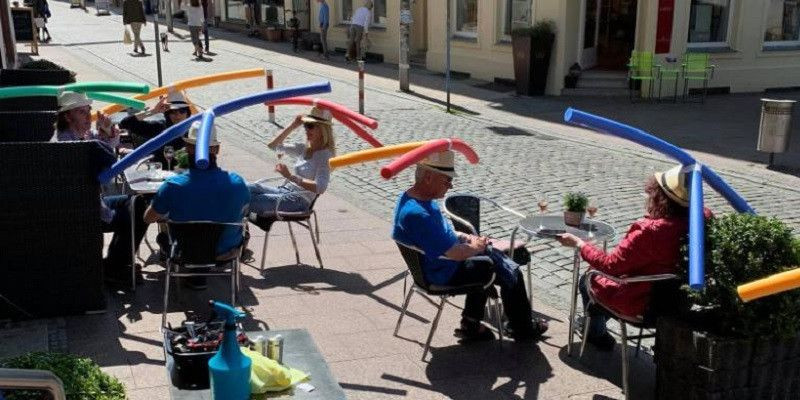 Pengunjung di Cafe & Konditorei Rothe di wilayah Schwerin, Jerman mengenakan topi busa warna-warni untuk menjaga jarak sosial/CNN