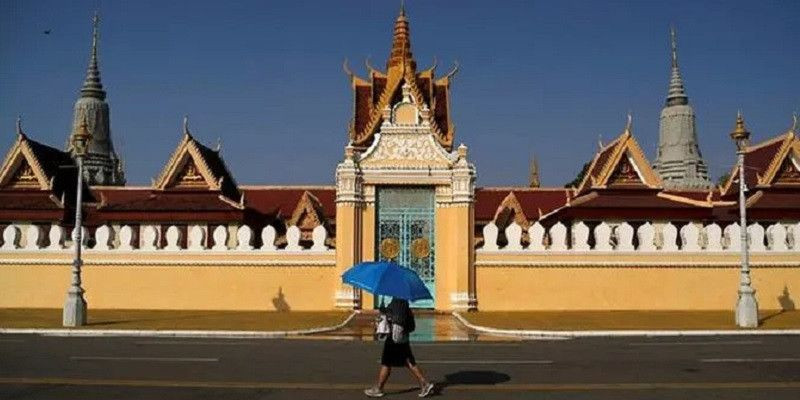 Seorang wanita berjalan di luar Istana Kerajaan yang telah ditutup untuk para pengunjung sebagai tindakan pencegahan terhadap penyebaran virus corona di Phnom Penh, Kamboja/Reuters