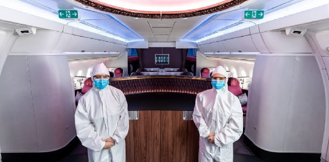 Pramugari Qatar Airways berpose di dalam kabin pesawat dengan mengenakan APD/CNN