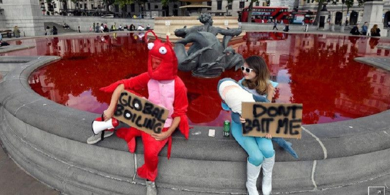 Sejumlah pengunjuk rasa hak hewan berpose di depan air mancur yang telah diberikan pewarna merah di London/Reuters