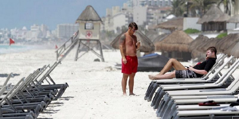 Sejumlah turis bersantai di pantai Meksiko yang sepi pada Juni 2020/Reuters