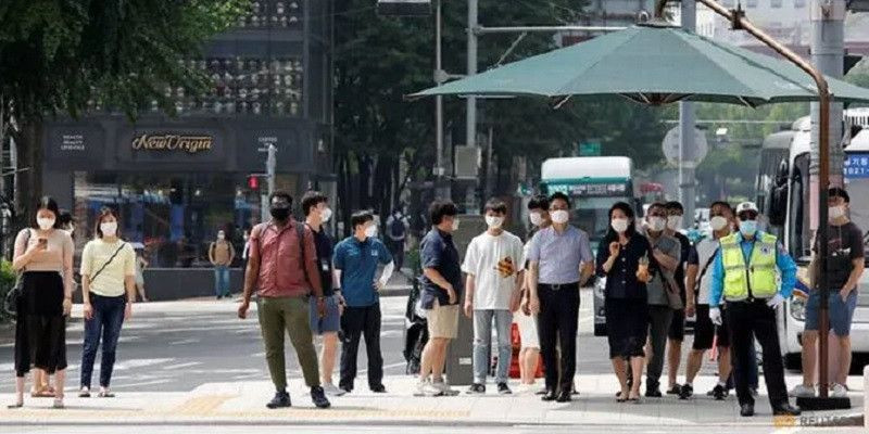 Sejumlah orang mengenakan masker saat menunggu di perlintasan zebra di pusat kota Seoul, Korea Selatan/Reuters