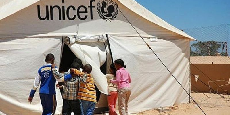 Anak-anak memasuki sekolah tenda yang didukung UNICEF di kamp transit Shousha di perbatasan Libya dengan Tunisia/ Net