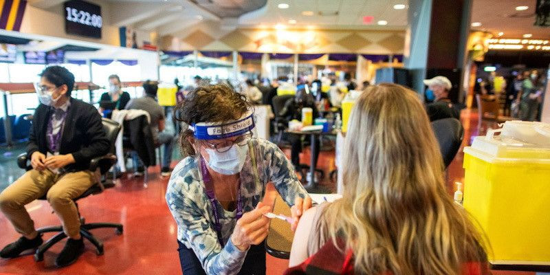 Seorang petugas kesehatan memberikan vaksin Covid-19 Pfizer/BioNTech di klinik vaksin pop-up Woodbine Racetrack di Toronto, Ontario, Kanada 5 Mei 2021/Reuters