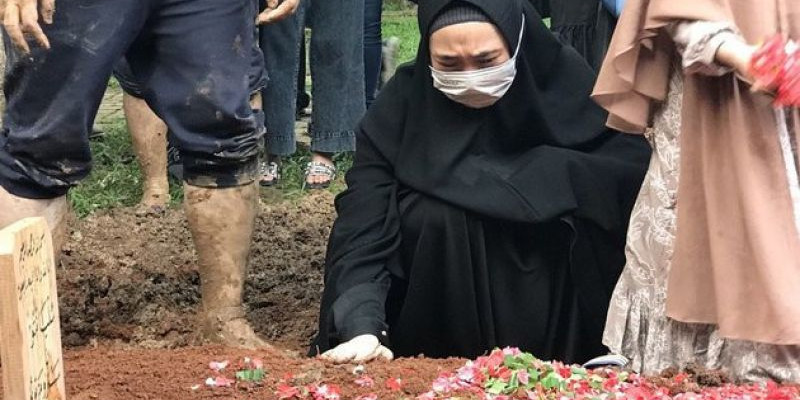 Sambil memegang tanah kubur mendiang ayahnya yang masih merah, Oki mengucapkan salam perpisahan sambil terus meneteskan air mata/ Foto: KapanLagi.com