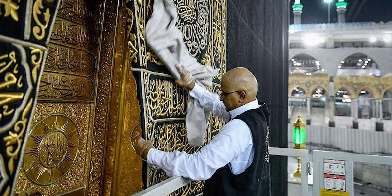 Petugas di Masjidil Haram sedang membersihkan pintu Kabah./Net