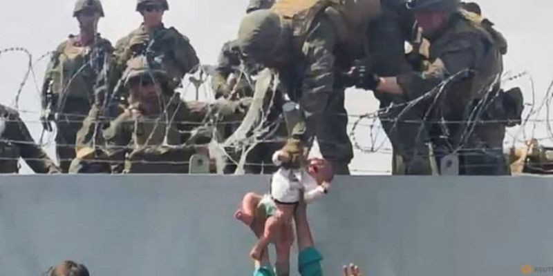 Cuplikan video itu menunjukkan seorang Marinir Amerika Serikat mengangkat bayi di atas dinding berkawat duri di bandara Kabul/Net