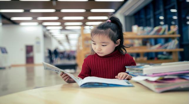 Ilustrasi anak membaca buku di perpustakaan/Net