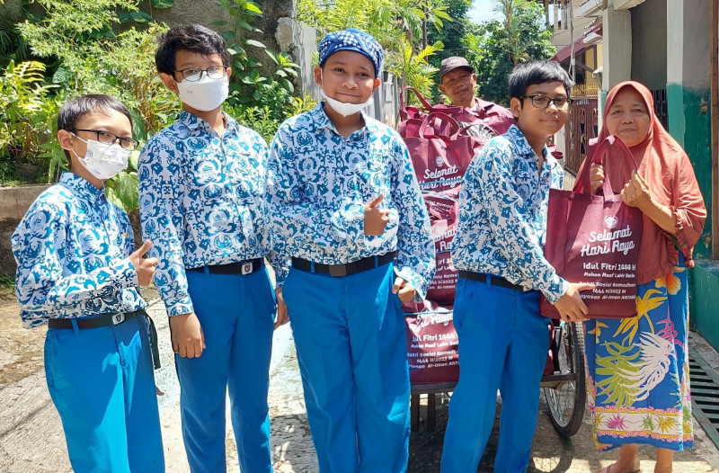 Murid SDIT Al Iman Kota Bekasi membagikan bantuan Paket Lebaran dari Yayasan Al Iman Antara kepada warga di Kota Bekasi, Sabtu, 15 April 2023/ Ist.