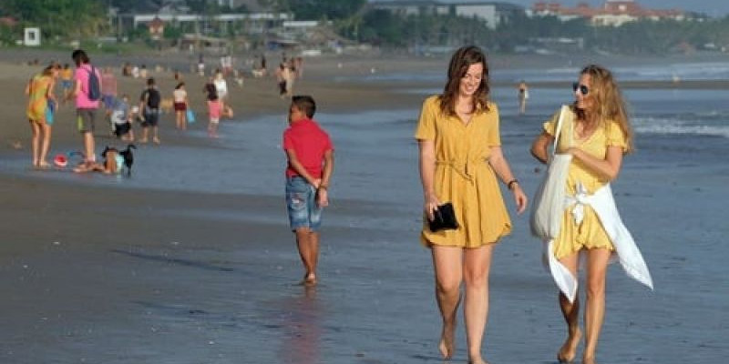 Turis Asing Berjalan Menikmati Pantai/net 