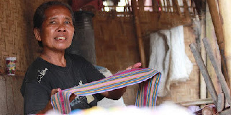 Seorang Ibu memperlihatkan hasil tenunannya di desa Sade, Lombok, NTB