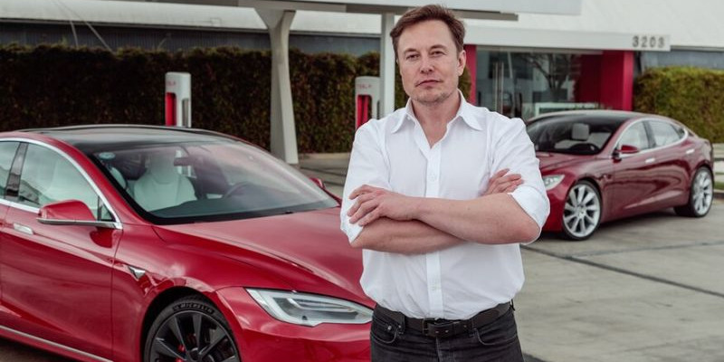 Elon Musk berdiri disamping mobil Tesla/NET