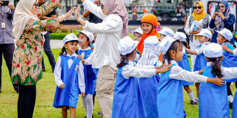 Penasihat DWP Eny Yaqut (berbaju putih) bermain ular naga bersama anak-anak usia dini/NET 