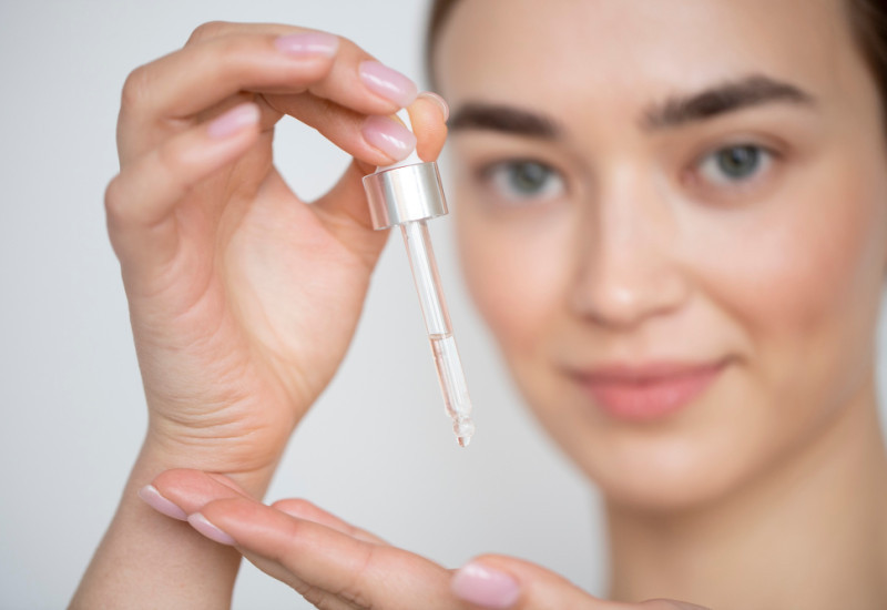 Ilustrasi perempuan mengaplikasikan serum. (Freepik)