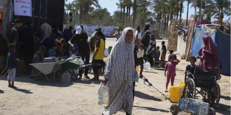 Warga Gaza mengakses air bersih di pengungsian. (AP)