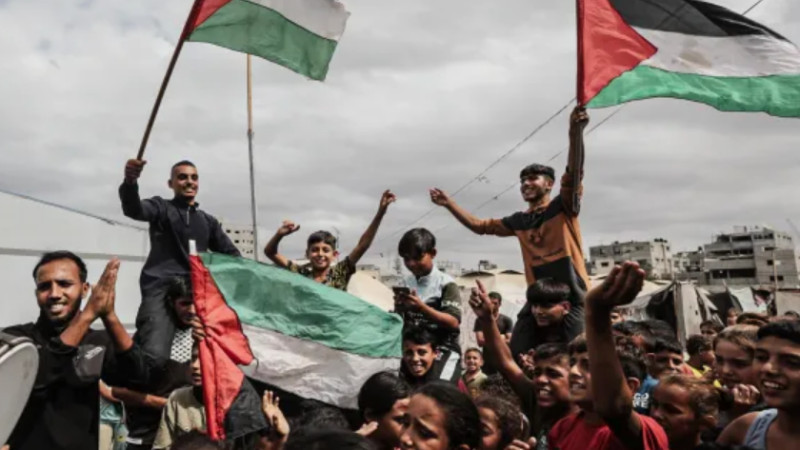 Warga Palestina di pengungsian Nuseirat kibarkan bendera sambut gencatan senjata Hamas-Israel (9/10). (Al Jazeera)